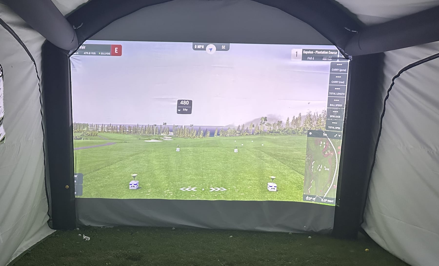 Playing a real course on the big screen inside the tent